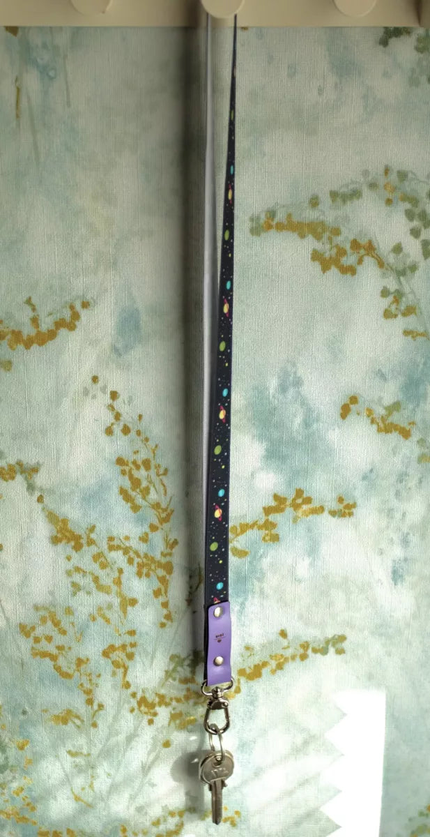 llavero largo con estampado de planetas y cuero lila